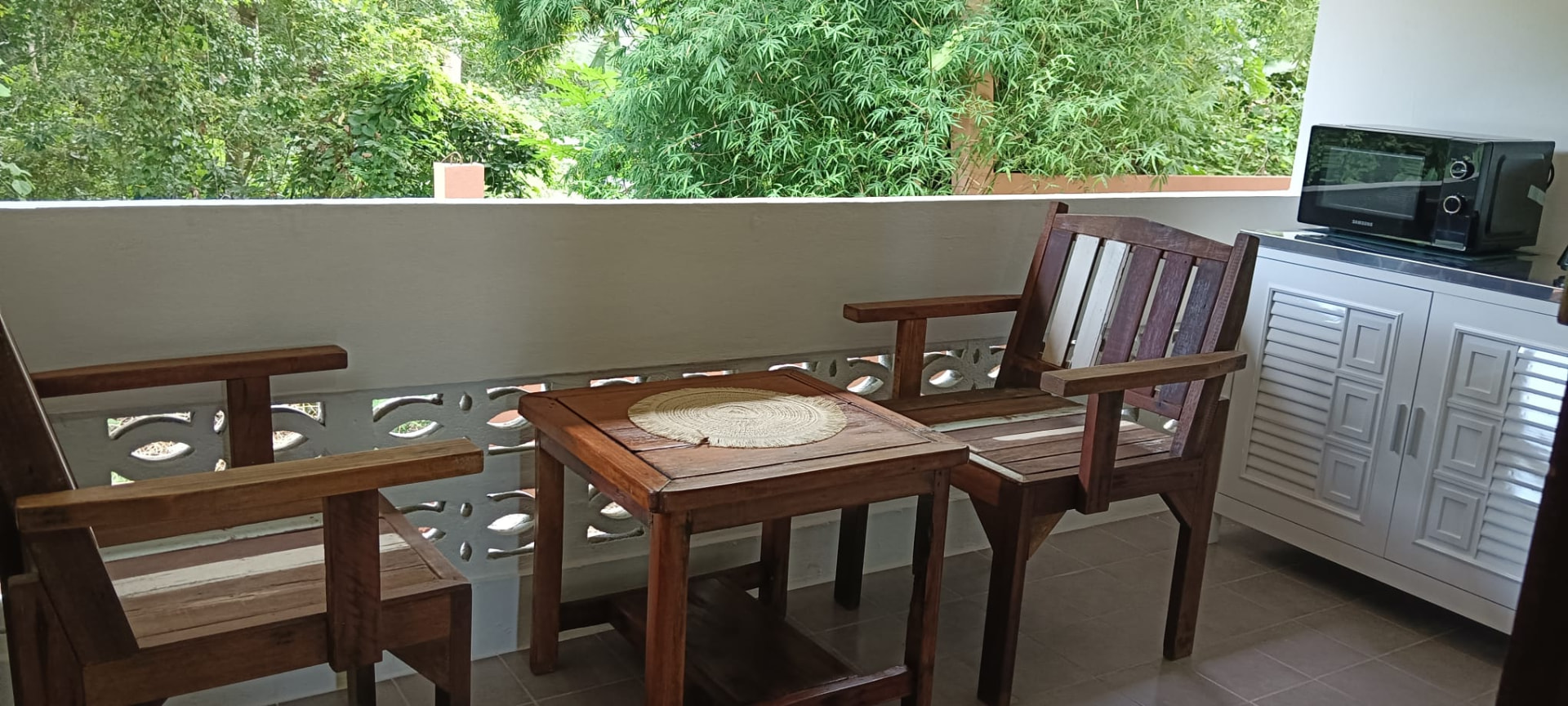 Jungle view balcony with seating and outdoor kitchenette