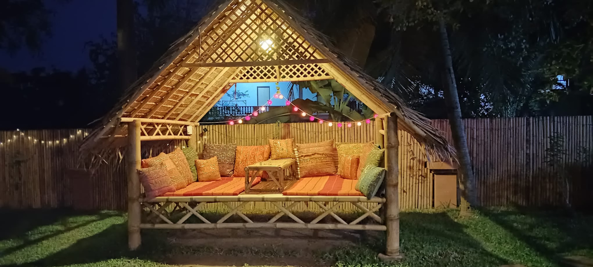 Bamboo sala lit with fairy lights at night